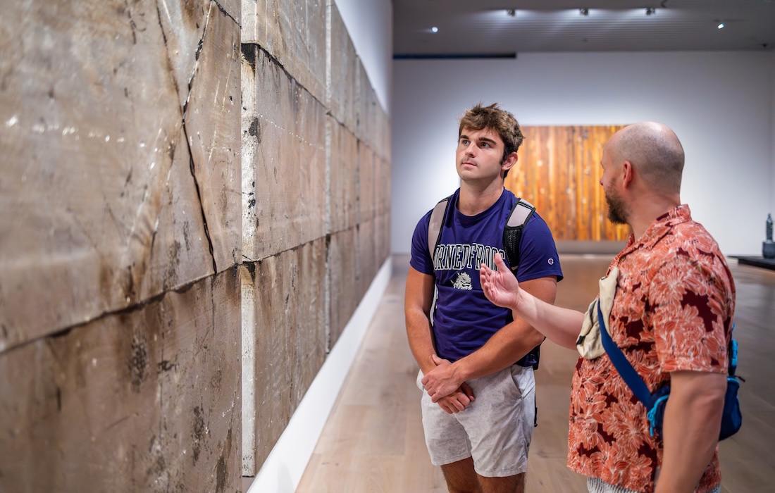 Two people discussing an art piece in a gallery