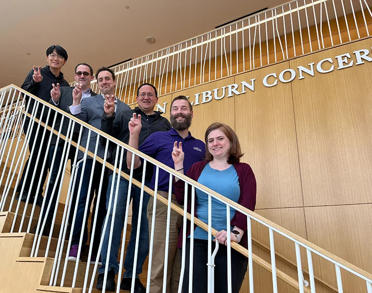 A group from TCU Music stand on the stairs of the Van Cliburn Concert Hall at TCU