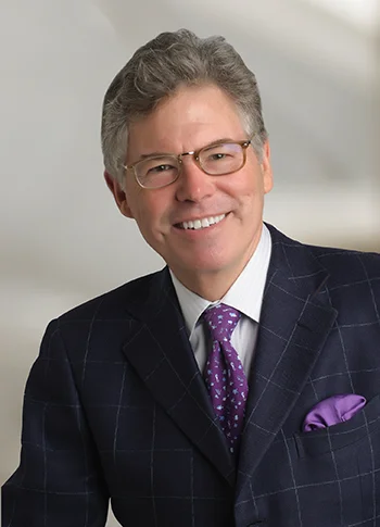 Michael Mullins, in a dark suit with purple tie