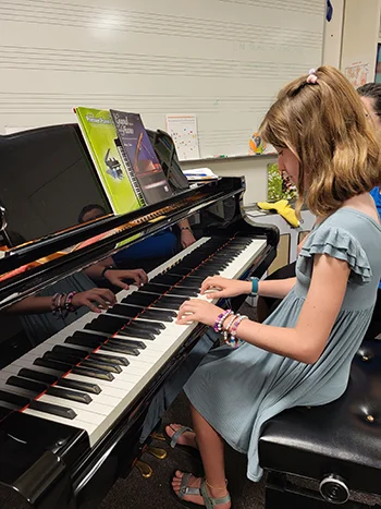 A young student practices on a piano