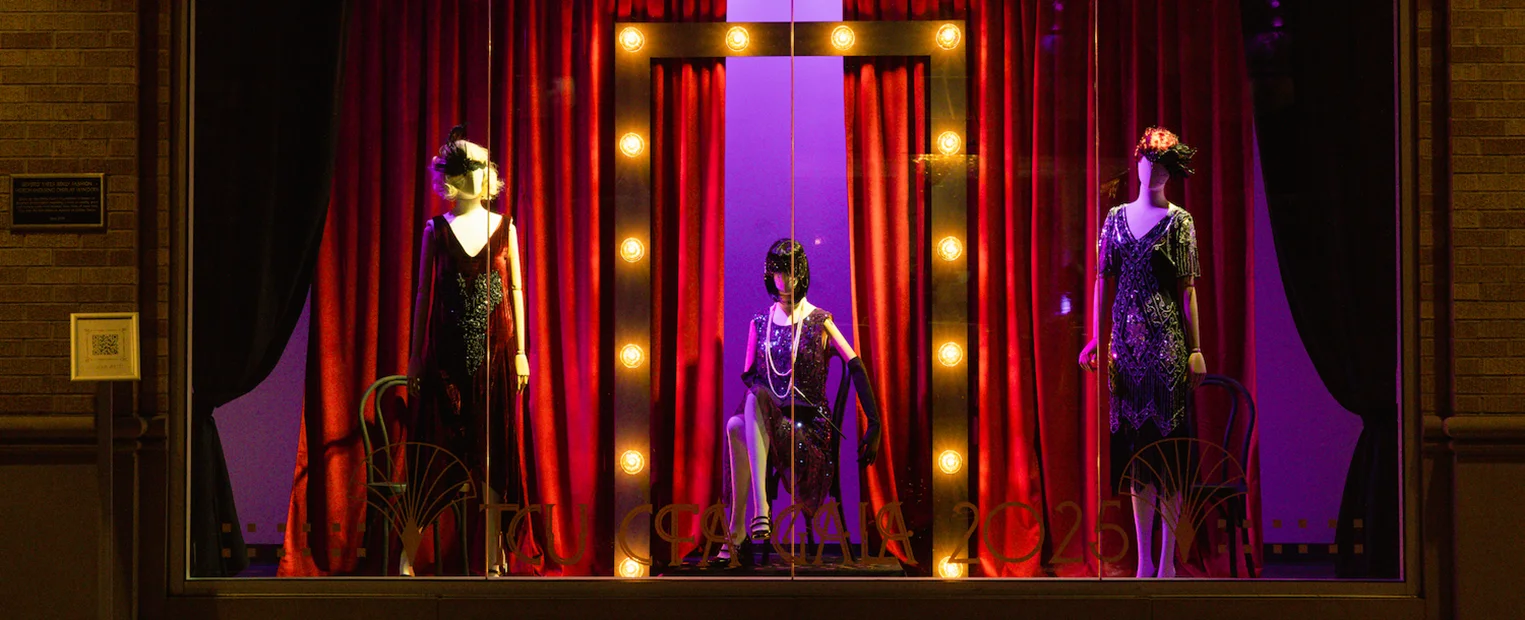 Three mannequins dressed in 1920s cabaret attire decorate a window display