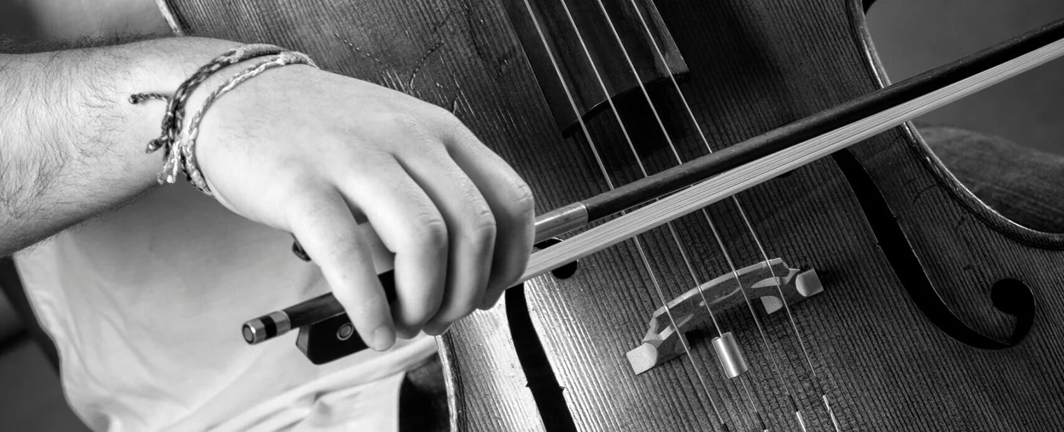 A cellist draws his bow across the strings