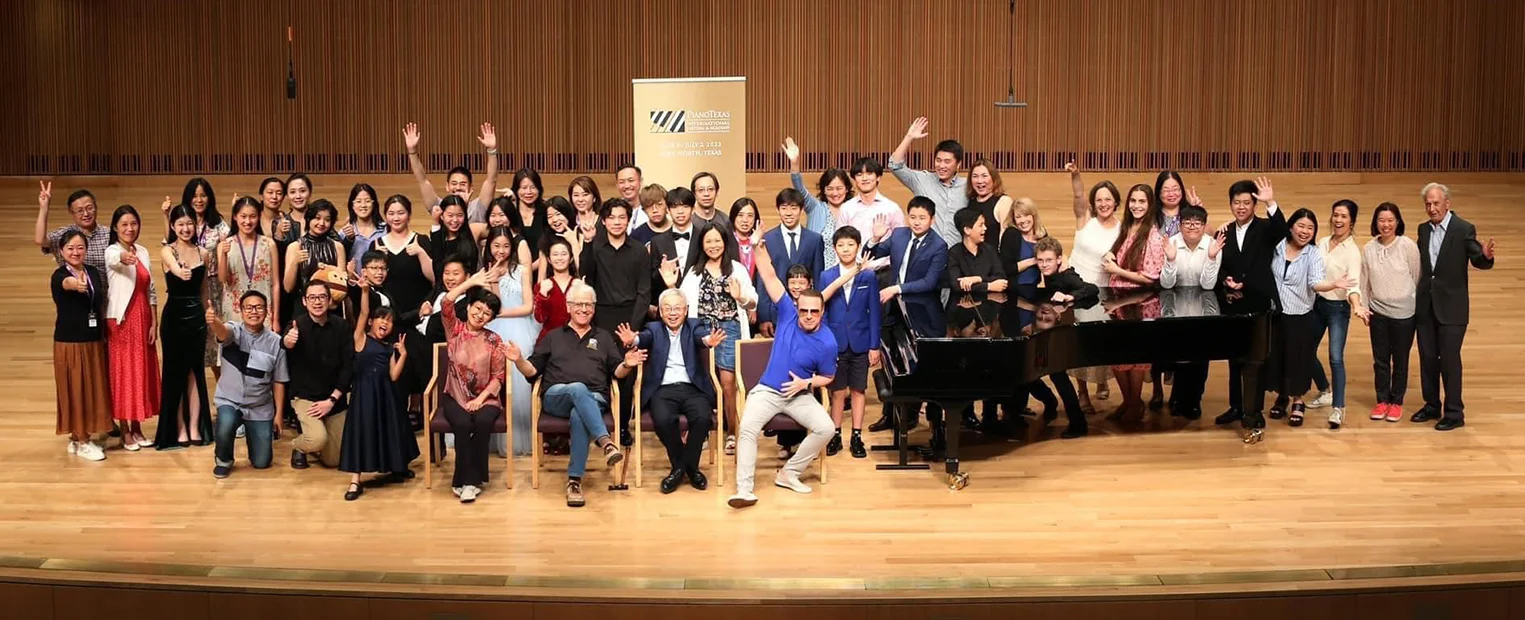 A large group of PianoTexas participants gather on the stage